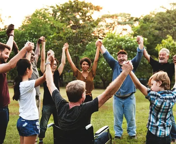 A disabled man being included in a happy group’s activity because of challenging stereotypes.